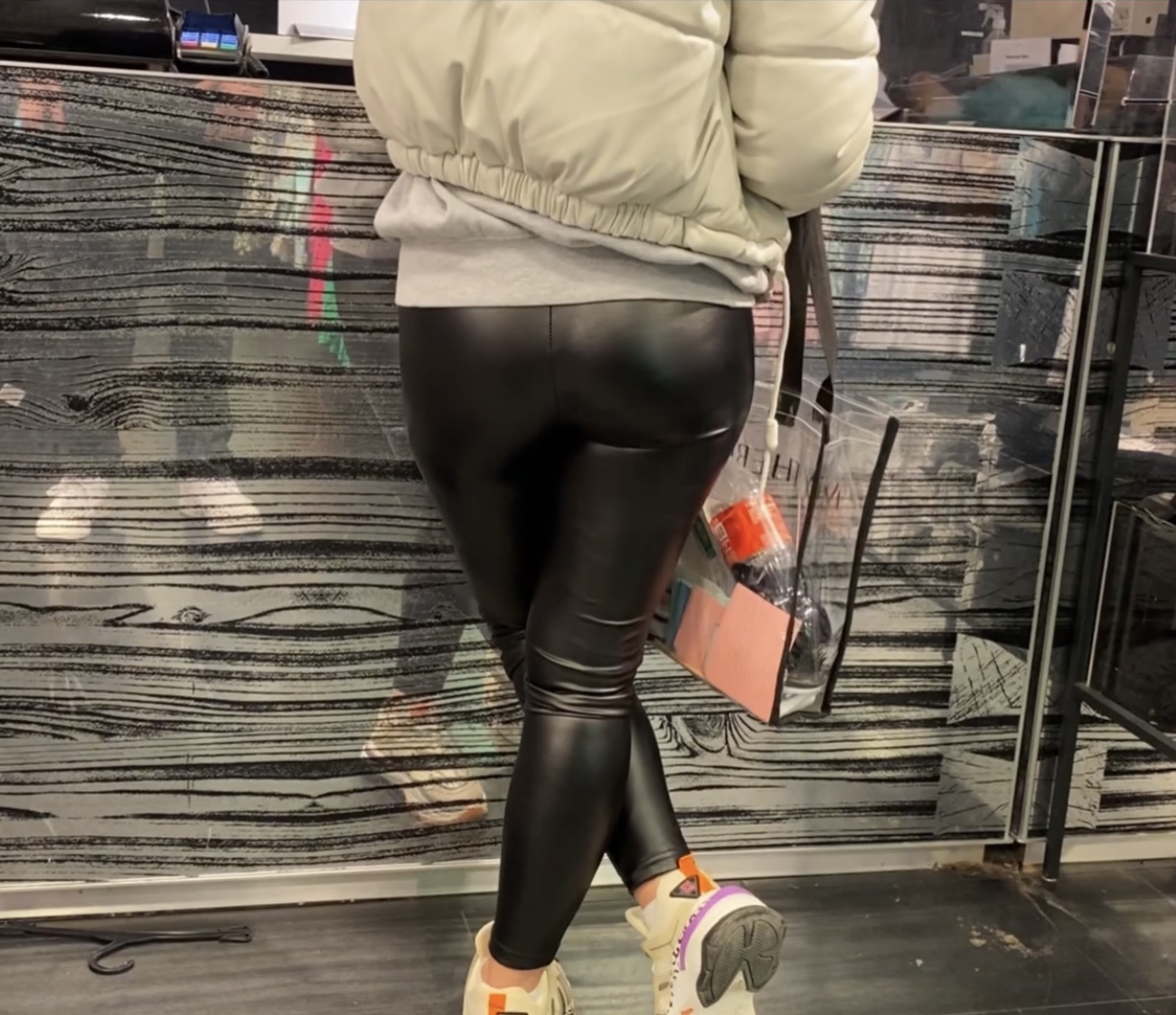 Tight shiny leather leggings with nice round ass in front of me during ...